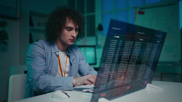 Male IT specialist successfully launches program on futuristic computer display
