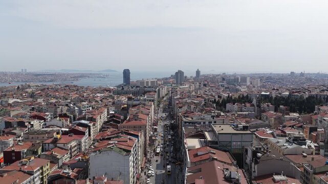 Flying over Istiklal Avenue in Istanbul, Turkey revealing urban cityscape with Bosphorus Strait and Asian side in background on sunny day