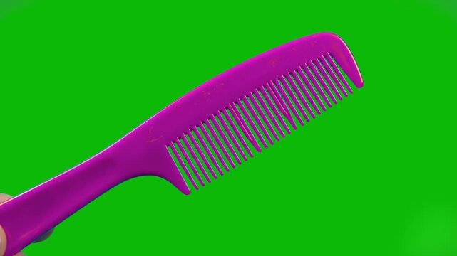 A 3D rendered purple plastic comb floats at an angle against a solid green background. This footage is ideal for hair care commercials or beauty tutorials requiring easy background removal via chroma 