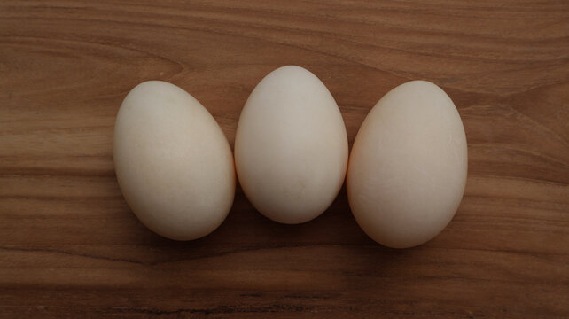 Top View of Three Fresh Eggs on Wooden Background