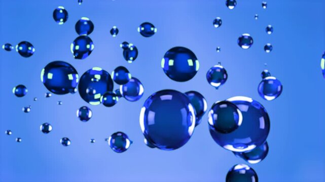Various sizes of blue spheres, representing oil droplets or gel particles, float suspended in a blue liquid. The animation shows the spheres moving and merging, suitable for science visualizations, co