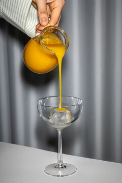 A hand pours juice into a glass