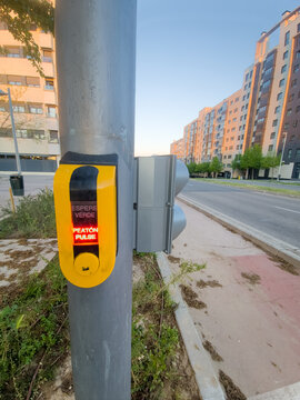 Pedestrian crossing button in glowing urban street