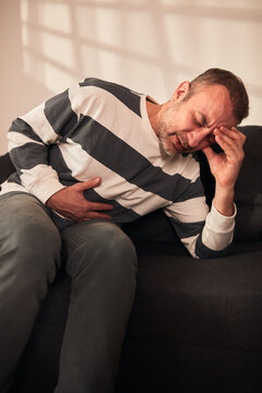 Man with gastritis, chest, stomach and abdominal pain at home.