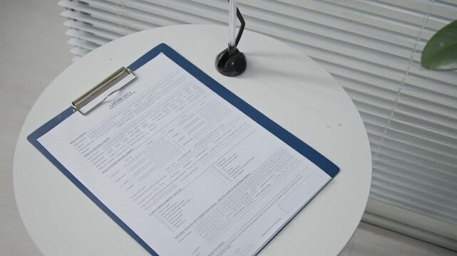 High angle shot of claim form with empty lines resting on table in waiting area of clinic
