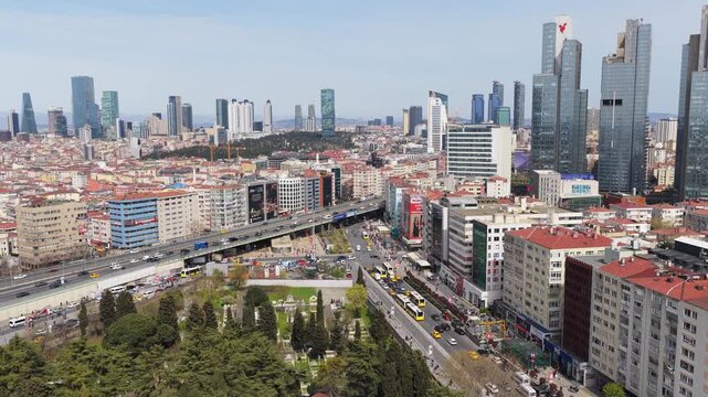 Istanbul cityscape showing bustling Zincirlikuyu intersection with heavy car traffic, large cemetery, modern Levent district skyline in background