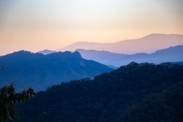 Obraz premium Beautiful sunset over the layered silhouettes of the Andes mountains in Argentina, featuring a purple and orange sky over a wild highland landscape