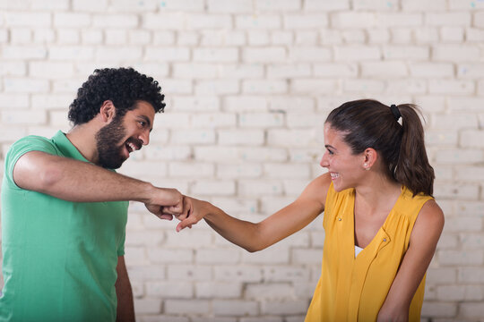 Young Middle Eastern coworkers sharing a friendly fist bump in a creative open office space