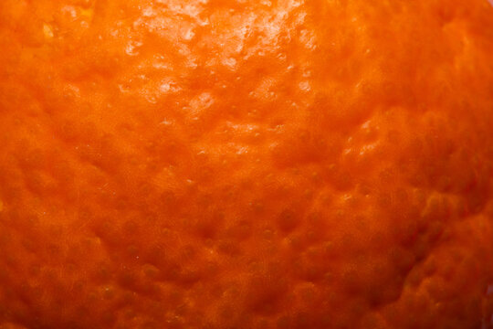 Extreme Close-up of Vibrant Orange Peel Texture,Macro,A detailed macro shot showcasing the intricate organic texture and porous surface of a fresh orange fruit peel. The image highlights the vibrant.