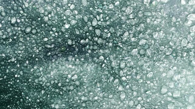Aerial view of frozen sea with floating ice floes and slush.