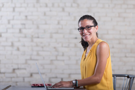 Young professional woman working on laptop in a bright coworking space for startups and entrepreneurs