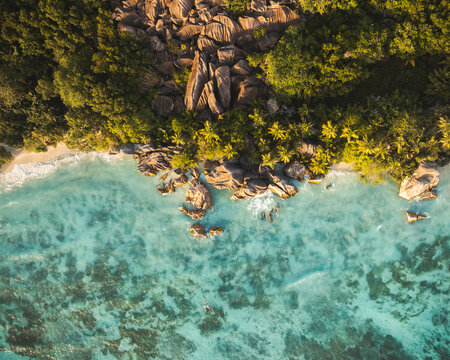 Aerial view of Anse Source d'Argent beach with turquoise water, granite rock formations, and lush palm trees, L'Union Estate, Seychelles.
