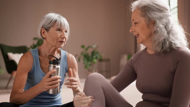 Senior woman in sportswear sharing latest news with friend after training