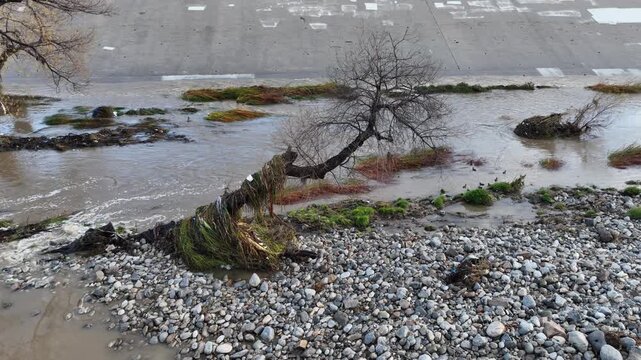 Aerial shot of flood damage and trash in the Los Angeles River after heavy rains.