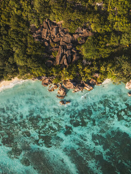 Aerial view of Anse Source d'Argent beach featuring iconic granite boulders, turquoise waters, and lush tropical forest in L'Union Estate, Seychelles.