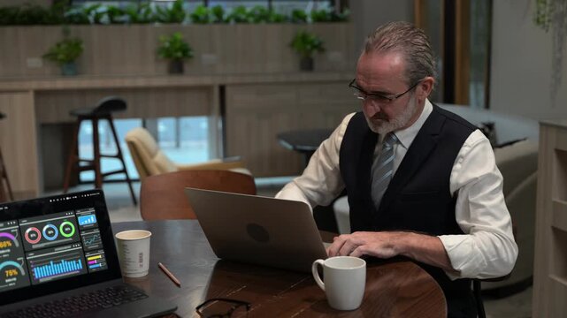 Focused senior business executive thinking deeply while analyzing corporate data on a laptop in a modern office. Mature entrepreneur solving complex problems and making strategic financial decisions.