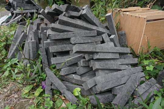 Stack of andesite stones commonly used for construction in Bali. Natural volcanic rock texture with rough surfaces and earthy tones, ideal for building, landscaping, and traditional architecture.
