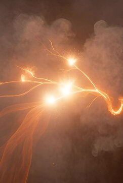 A dynamic abstract image featuring a bright, flowing orange energy wave illuminated by small sparks and swirling smoke. This vibrant visual evokes a sense of power and movement, ideal for concepts rel