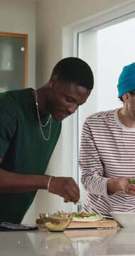 Cooking, ingredients and friends with pizza in kitchen for dinner, lunch and meal prep together. Home, culinary and men with vegetables, recipe and help for nutrition, wellness and prepare supper