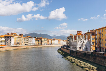 Obraz premium Arno River flowing past the Santa Maria della Spina church and historic buildings in Pisa, Tuscany, Italy