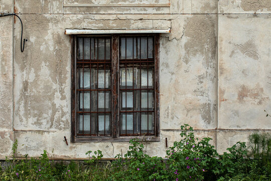 muro esterno di edificio vecchio e grigio con finestra vecchia in legno