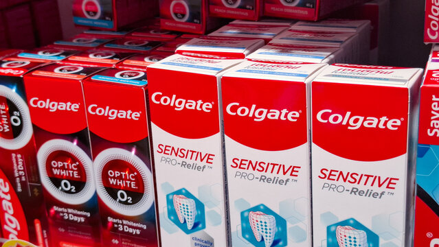 Rows of Colgate Optic White and Sensitive Pro Relief Toothpaste Boxes on Retail Shelf in Supermarket on April 12, 2026 in Bangkok, Thailand