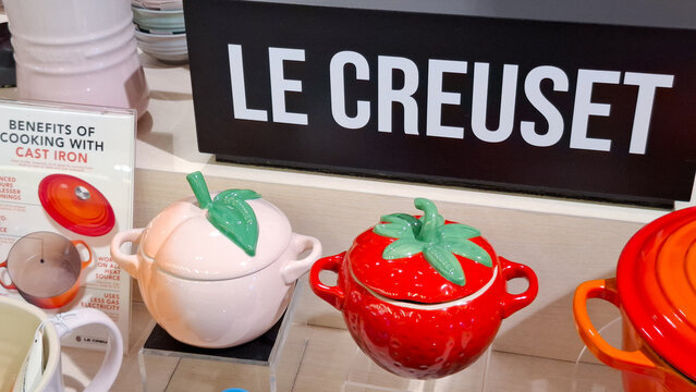 Premium Le Creuset stoneware ceramic cocotte collection in fruit and vegetable shapes displayed at a luxury kitchenware store with brand signage on April 14, 2026 in Bangkok, Thailand