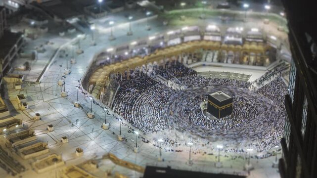 Tilt shift time lapse of sunrise over the Makkah Clock Tower and Great Mosque of Mecca with sunlight hitting the skyscraper facade in Saudi Arabia. 
