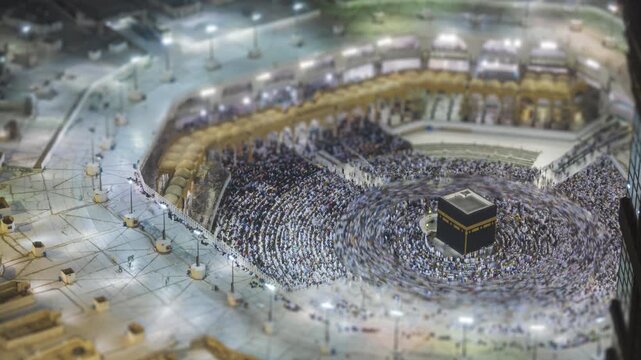Tilt shift time lapse of sunrise over the Makkah Clock Tower and Great Mosque of Mecca with sunlight hitting the skyscraper facade in Saudi Arabia. Zoom out motion timelapse.