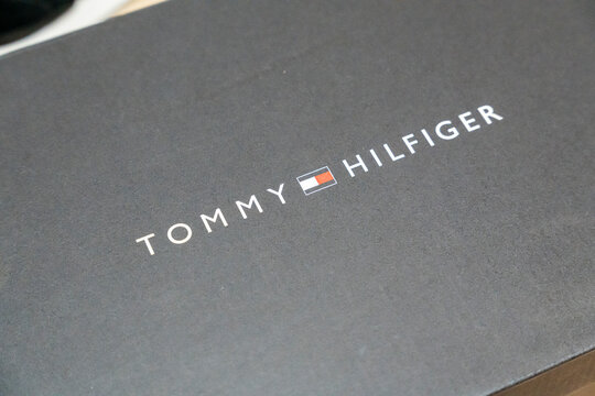 Warsaw, Poland - April 20, 2026: Close-up of a Tommy Hilfiger logo on a black packaging box. This image highlights luxury branding and retail packaging design.