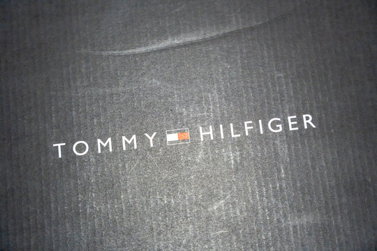 Warsaw, Poland - April 20, 2026: Close-up of a Tommy Hilfiger logo on a black textured surface, showcasing branding in fashion related to luxury and lifestyle.