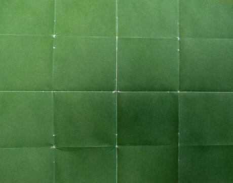 High-resolution green foil texture featuring a visible grid of folds and creases.