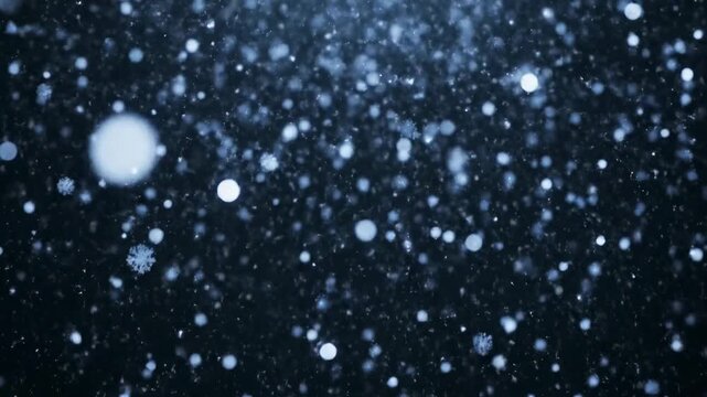 Abstract shot of falling snowflakes against a deep dark background