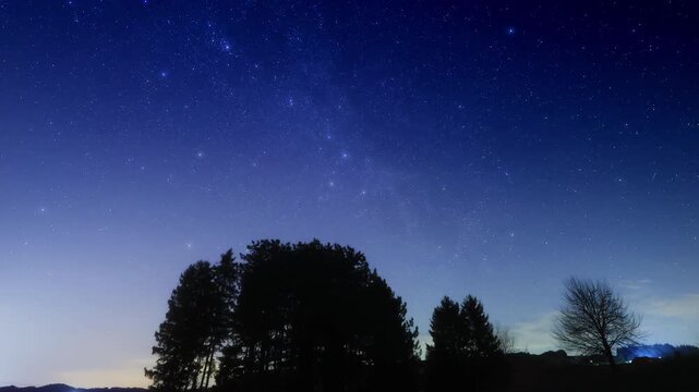 Constellations, zodiacal light and Milky Way stars on a dark countryside skies. Time-lapse video.