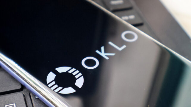 A close-up view of a laptop screen displaying the OKLO logo on a black background
