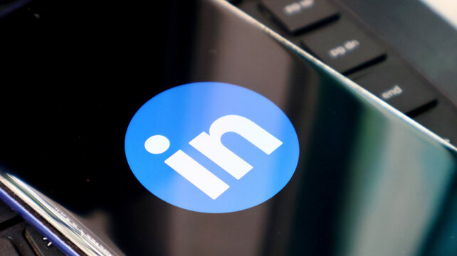 A close-up of the LinkedIn logo on a laptop screen in a modern office setting