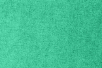 Fototapeta premium Fabric in bright green color laying flat on the surface for crafting and design purposes in a well-lit room