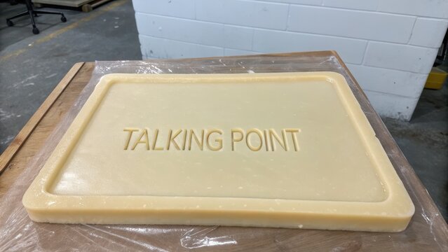 Block of Wax with Engraved Text "Talking Point" on Work Surface