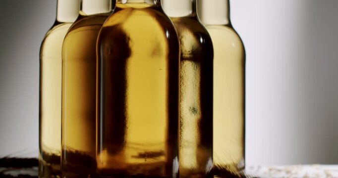 Golden light beer or cider bottles sliding on a conveyor belt during the automated bottling and manufacturing process in a factory, showing the industrial production of alcoholic beverages