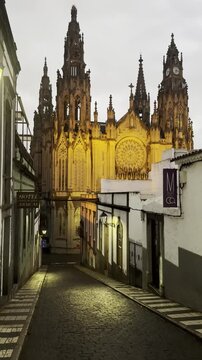 Impressive gothic Arucas Cathedral rising above a narrow cobblestone street after rain in Arucas village, Gran Canaria, Canary Islands, Spain.
