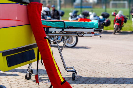 Professional medical stretcher prepared for emergency response at a motorcycle gathering, outdoor medical service equipment, event safety and security, paramedic gear, emergency preparedness, healthca
