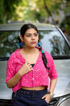 Stylish young Indian woman wearing a colourful casual outfit with vibrant accessories, posing outdoors in natural daylight
