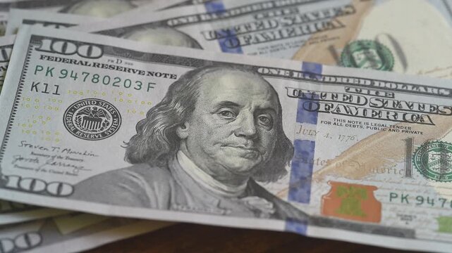 Counting $100 bills on a table. Money being placed on a table, close-up on the $100 bills.