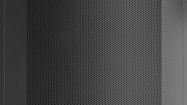 Perforated Metal Surface. A black perforated surface with a repeating pattern of holes creates a textured, industrial look.