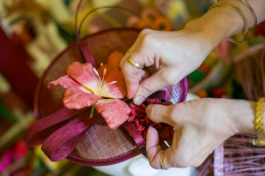 Hands arranging flowers on handmade fascinator