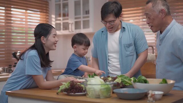 Happy multigenerational family preparing healthy meal together in kitchen, parents and grandfather bonding with child, fresh food and warm lifestyle concept