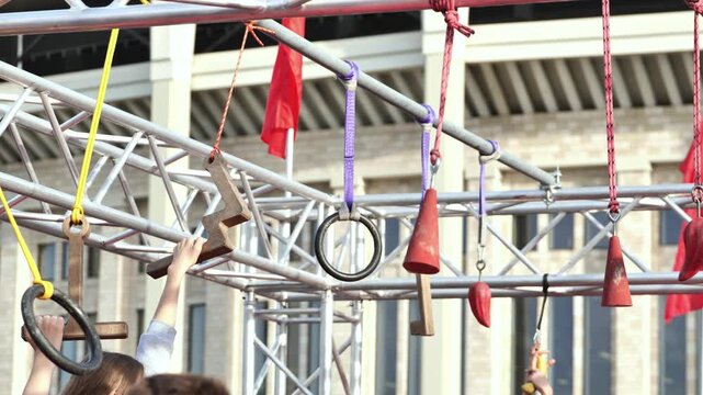 Hands holding obstacle course elements during outdoor fitness challenge event