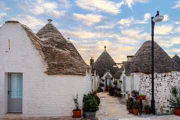 Fototapeta premium Alberobello miasto we Włoszech, słynie z unikatowych form budownictwa – domów typu trulli, które są okrągłe i mają stożkowate dachy z kamienia.