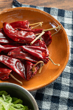 Dried guajillo chilies in traditional Mexican clay plate