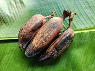 Three ripe roasted plantains musa x paradisiaca sweet cooked bananas on fresh green banana leaf musa x paradisiaca © ByronObed